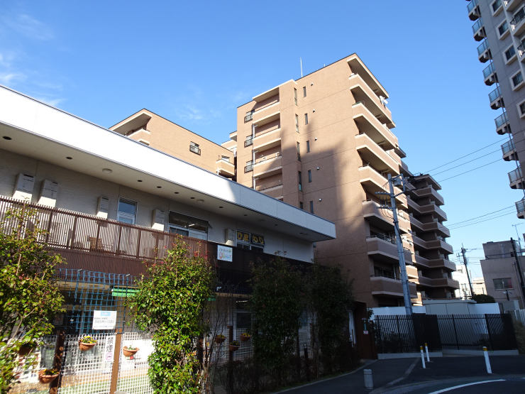 ▲“ビューネ梅島駅前”と、暫定利用と思われる保育所。保育所の敷地は道路用地に含まれる。