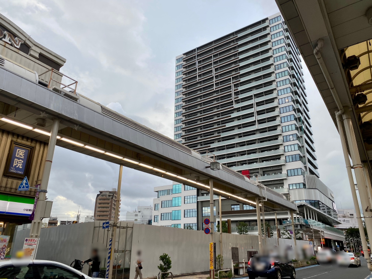 ▲フラワーロード商店街から見た“プラウドタワー小岩ファースト”。手前のバリケード部分でⅢ街区が建設中。