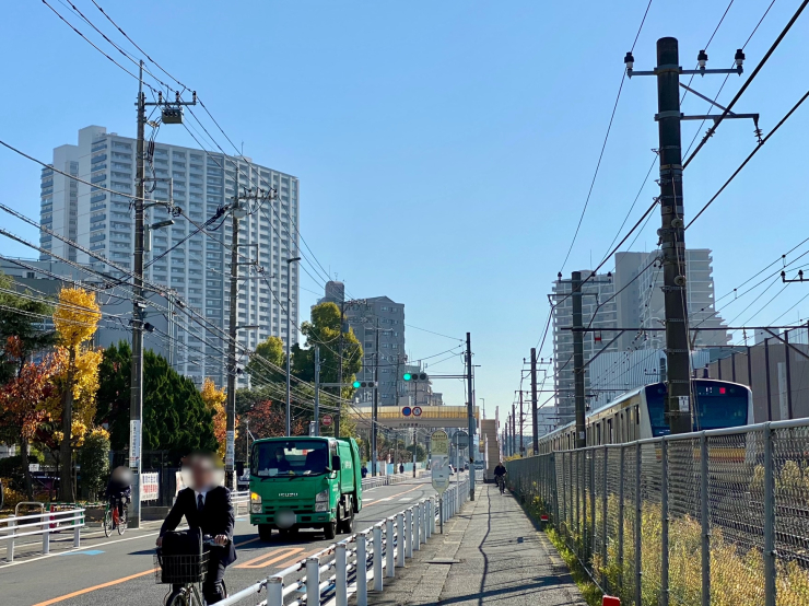 ▲KSPに隣接する｢ザ・タワー&パークス田園都市溝の口｣(左)と南武沿線道路、JR南武線。