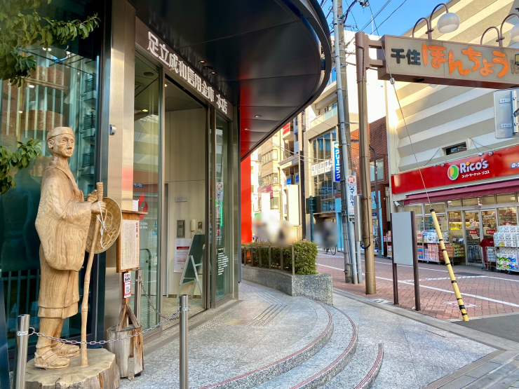 ▲千住本町商店街の南側入り口。街の入り口に、当地ゆかりの松尾芭蕉の像が立っている(左)。